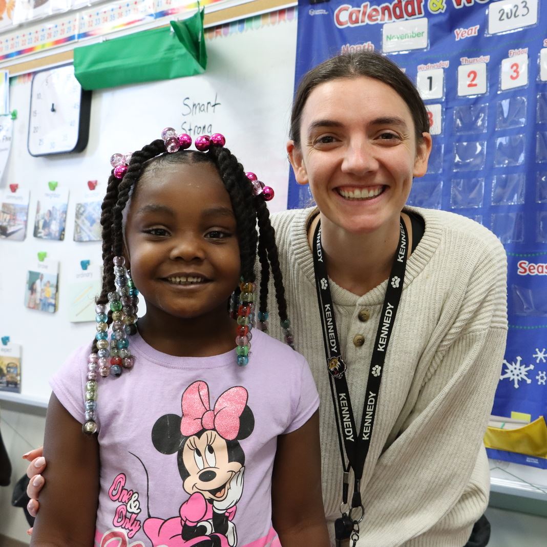  A student and teacher smile in the classroom